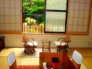 Zimmer mit Stühlen, einem Tisch und einem Fenster in der Unterkunft Shima Onsen Ichigekan in Nakanojo
