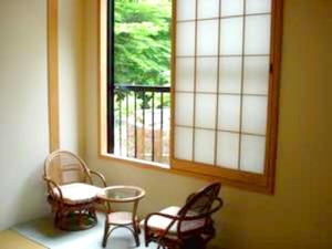 una stanza con sedie, tavolo e finestra di Shima Onsen Ichigekan a Nakanojo