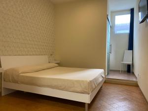 a small bedroom with a bed and a window at Acquaviva Experience B&B in San Vincenzo