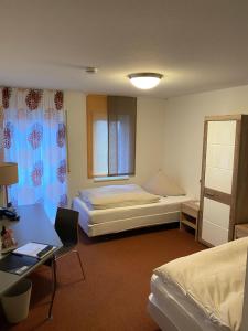 a room with two beds and a desk and a desk at Hotel Astra Rastatt in Rastatt