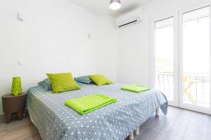 アヴィニョンにあるStudio Malpeignéの白いベッドルーム(緑の枕が付くベッド付)