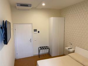 Habitación con cama, puerta y silla en Acquaviva Experience B&B, en San Vincenzo