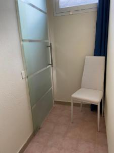 una silla y una puerta de cristal en una habitación en Acquaviva Experience B&B, en San Vincenzo