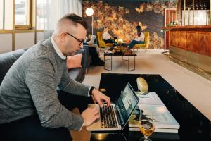 a man sitting at a table using a laptop computer at Hotel Sparre in Porvoo