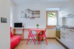 une cuisine avec une table et une chaise rouges dans l'établissement Cesa Crepaz piccolo, à Canazei