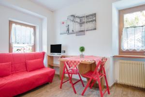 sala de estar con sofá rojo y mesa en Cesa Crepaz piccolo, en Canazei