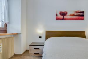 1 dormitorio con 1 cama y una pintura en la pared en Cesa Crepaz piccolo, en Canazei