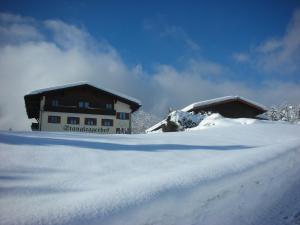 un par de edificios en la nieve en Stangleggerhof en Wiesing