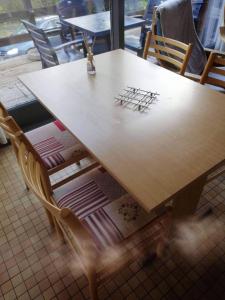 una mesa de madera con sillas alrededor en un restaurante en Chalet village vacances en Waulsort