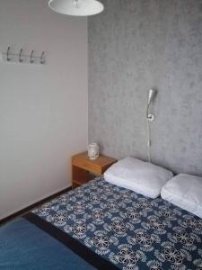 1 dormitorio con 1 cama con manta azul y blanca en Chalet village vacances en Waulsort