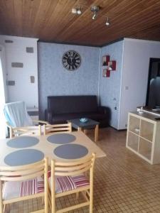 sala de estar con mesa, sillas y sofá en Chalet village vacances en Waulsort