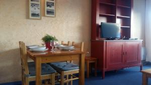 a wooden table with chairs and a tv on top at Le Tyrol in Les Deux Alpes