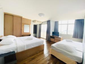 ein Hotelzimmer mit 2 Betten und einem TV in der Unterkunft City Residence in Bangkok
