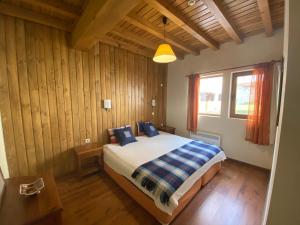 a bedroom with a bed in a room with wooden walls at Katarino Spa Chalet in Razlog
