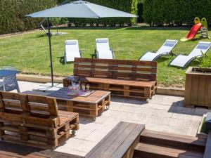 two wooden benches and a table and chairs and an umbrella at VINTAGE 1894 & SPA in Villers-sous-Châtillon