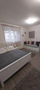 a large bedroom with two beds and a couch at Amira apartman in Eger
