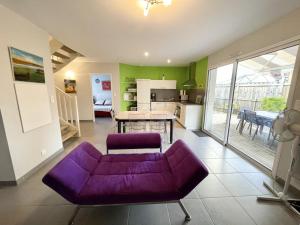 ビスカロッスにある36 AVENUE ROSNI JEUNE -012の紫色のソファ付きのリビングルーム、キッチンが備わります。