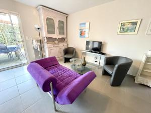 ビスカロッスにある36 AVENUE ROSNI JEUNE -012の紫色のソファと椅子が備わるリビングルーム