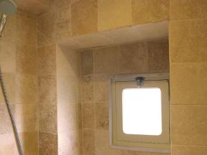 a shower stall with a window in a bathroom at Maison O'Galop in Beynac-et-Cazenac