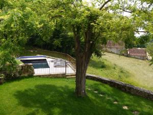 Ein Baum mitten im Garten mit einem Haus in der Unterkunft Maison Linol in Beynac-et-Cazenac