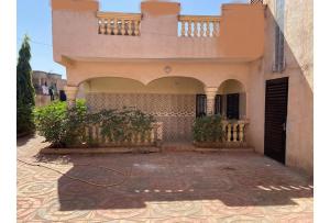 a house with a gate and a courtyard at Villa Chambre B climatisée douche Cuisine salon in Bamako