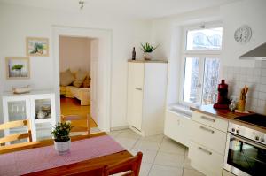 een keuken met witte kasten en een tafel in een kamer bij Ferienwohnung Simon in Füssen +6 foto's