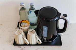 a black coffee maker sitting on a tray with bottles at Poolrada Boutique Hotel - SHA Plus in Thalang