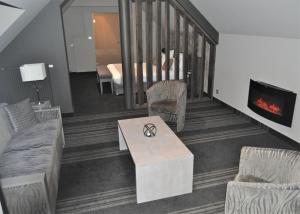 ein Wohnzimmer mit einem Sofa und einem Kamin in der Unterkunft Hotel Saint Daniel in Péruwelz