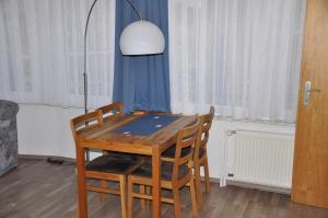 a dining room table with four chairs and a lamp at Seevilla Wietjes Whg 4 in Baltrum