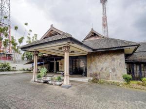 a house with a stone building with a tower at Hotel Mataram Cipanas Syariah Mitra RedDoorz in Pasakon 1