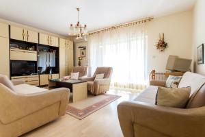 a living room with a couch and chairs and a tv at Apartment Maria in Malinska