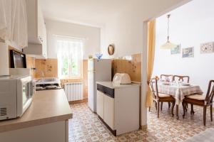 a kitchen with a refrigerator and a table with chairs at Apartment Maria in Malinska