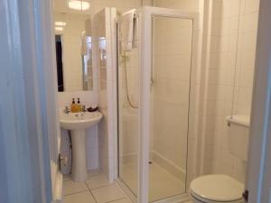 a bathroom with a shower and a toilet and a sink at Beech House Hotel in Reading