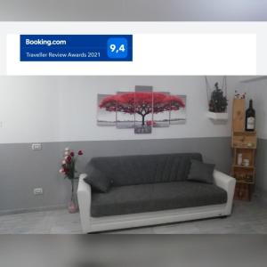 un divano in soggiorno con un dipinto di fiori rossi di Casa Mia a Verona