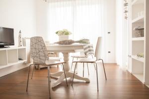 a dining room with a white table and chairs at La Casa di Giò in Caorle