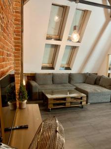 sala de estar con sofá y mesa en Apartamenty Młyńska 4, en Gliwice