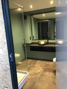 een badkamer met een wastafel, een toilet en een spiegel bij De Tuinschuur in Empe