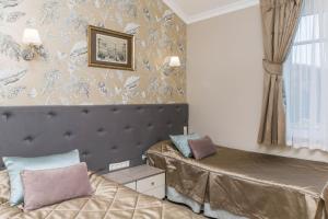 a bedroom with two beds and a wall with wallpaper at Ladozhskaya Usadba in Niemelanhovi