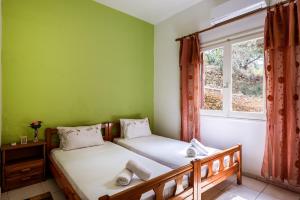 two beds in a room with a window at Antonis Studio in Sfinárion