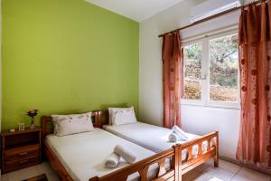 2 camas en una habitación con ventana en Antonis Studio, en Sfinárion