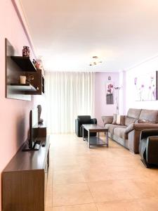 ein Wohnzimmer mit einem Sofa und einem Tisch in der Unterkunft SYDNEY SUN & BEACH apartments in Alicante