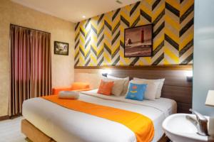 una camera d'albergo con letto e lavandino di Sans Hotel Ekkon Yogyakarta by Reddoorz a Ngabean