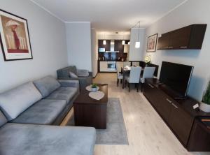 a living room with a couch and a dining room at Apartament przy hotelu Aquarius in Kołobrzeg