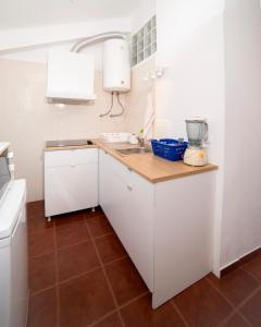 a small kitchen with white cabinets and a sink at Casa da Anita in Aldeia do Meco