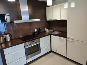 a kitchen with white cabinets and a sink at Apartament przy hotelu Aquarius in Kołobrzeg