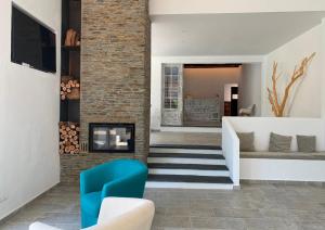 a living room with a fireplace and a blue chair at Hotel Misty in Cadaqués