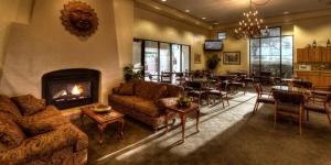 a living room with a fireplace and a dining room at Gateway Studio Suites in Sierra Vista