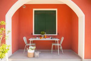 an orange wall with a table and two chairs at La Casa di Giò in Caorle