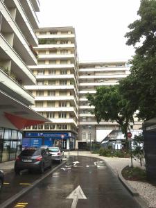 a parking lot with cars parked in front of a large building at Studio BRITTANY in Chambéry