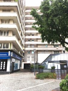 a tall building with a parking lot in front of it at Studio BRITTANY in Chambéry